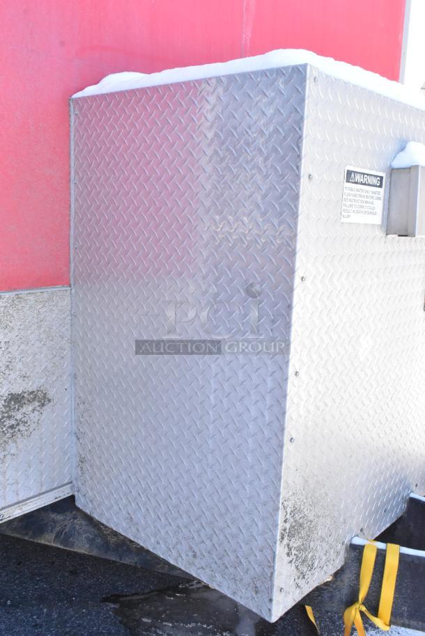 Diamond-plated steel enclosure with warning label on a red 28' Wendy's fast food trailer. Appears clean and sturdy.