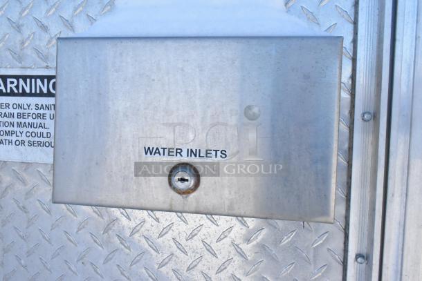 Metal panel on a fast food trailer labeled "Water Inlets" on a diamond plate surface.