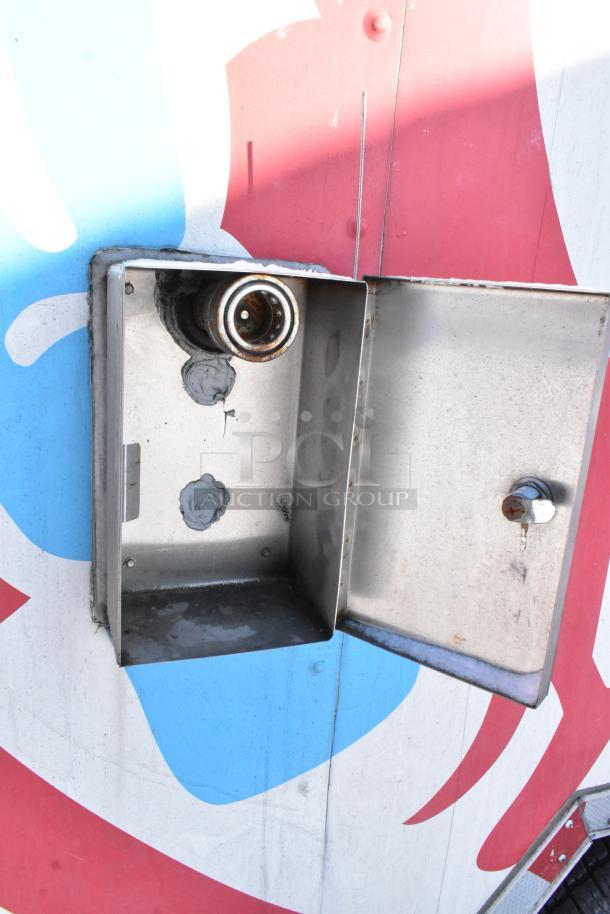 Exterior detail of a 28' Wendy's fast food trailer showing an open metal utility panel, with a colorful design background.