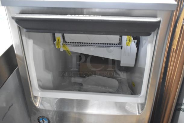 Brand new 2026 Hoshizaki commercial self-contained ice machine, stainless steel, interior view with new condition tags.
