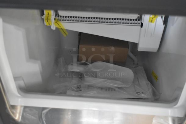"Brand new 2026 Hoshizaki commercial ice machine interior, includes ice scoop and manual, with protective packaging and yellow caution tags."
