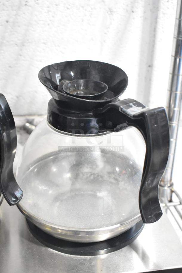 Avantco 177W52 countertop 2-burner coffee pot warmer with two clear, black-handled coffee pots. 120 volts, 1 phase.