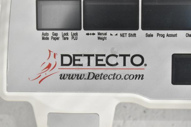 Detecto DL1030P digital scale with label printer, featuring control panel with logo and website.