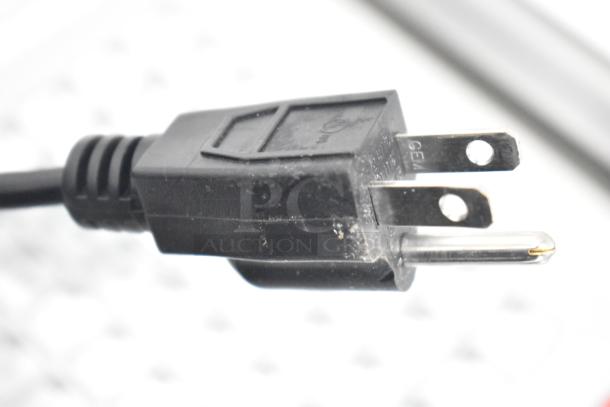 Close-up of a standard power plug, black and slightly worn, associated with the Detecto DL1030P digital scale system.