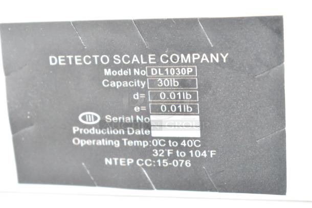 Label close-up for Detecto DL1030P 30 lb digital scale, shows model, capacity, and operating temp range.