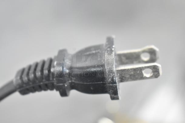 Close-up image of a black power plug for the Carnival King 382CPO12TS pizza/snack oven, showing prongs and cord condition.