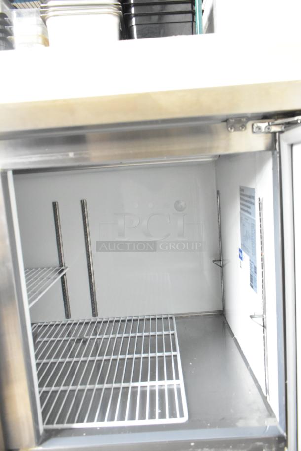 2024 Avantco 178APPT91HC commercial pizza prep table with stainless steel interior, wire shelving, and commercial casters.