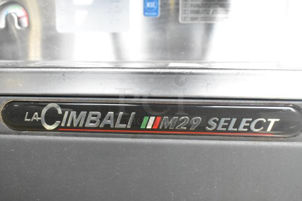 La Cimbali M29 Select DT/2-NF Espresso Machine label. Model info and logo on a metallic background.