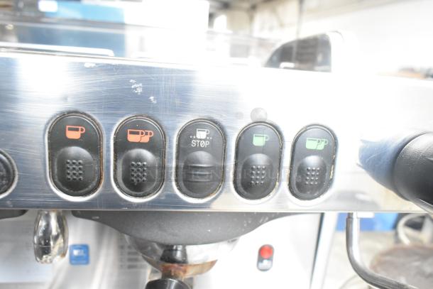 La Cimbali M29 Select DT/2-NF espresso machine control panel with cup icons, stop button, and visible wear.