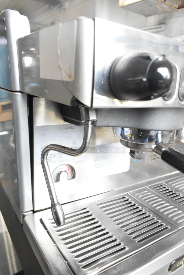 La Cimbali M29 Select DT/2-NF espresso machine with 2 portafilters, 2 steam wands, 208/240V. Metal body, visible wear.