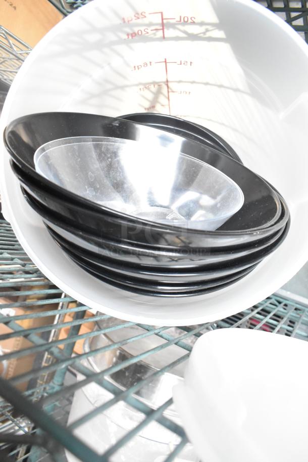 Three-tier lot with various items, including black plastic bowls, white cylindrical bins, and a marked measuring container.