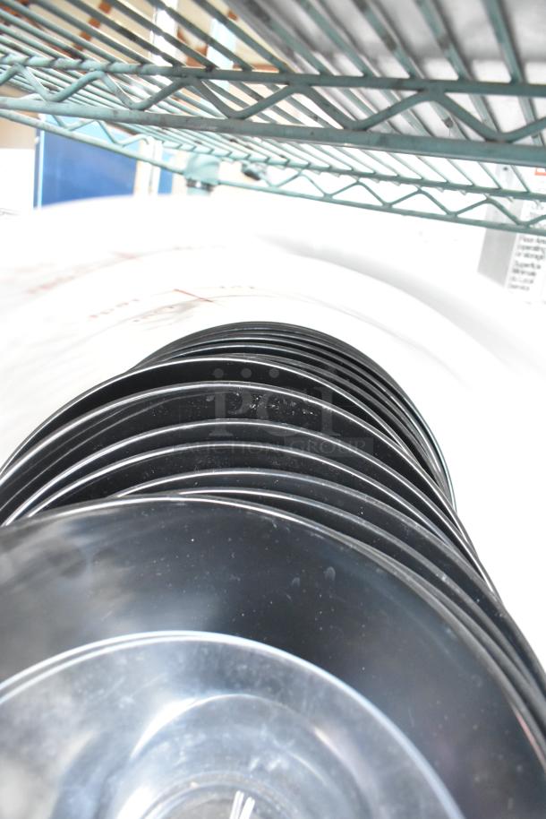 Three-tier lot of black poly drop-in bin lids stacked under a metal rack. Item appears in good condition.