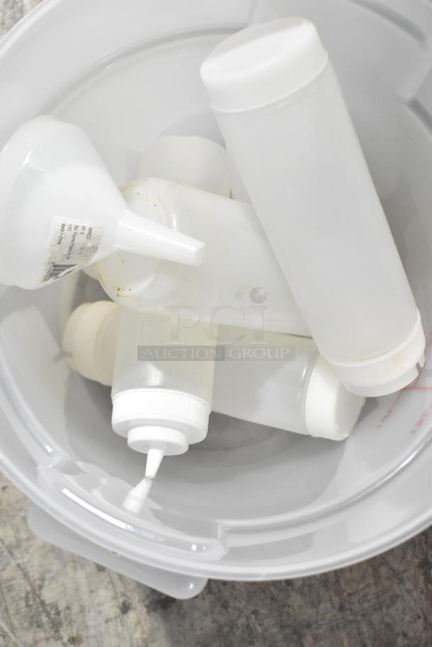 Three white plastic squeeze bottles inside a large poly cylindrical bin, showing a barcode label on one.
