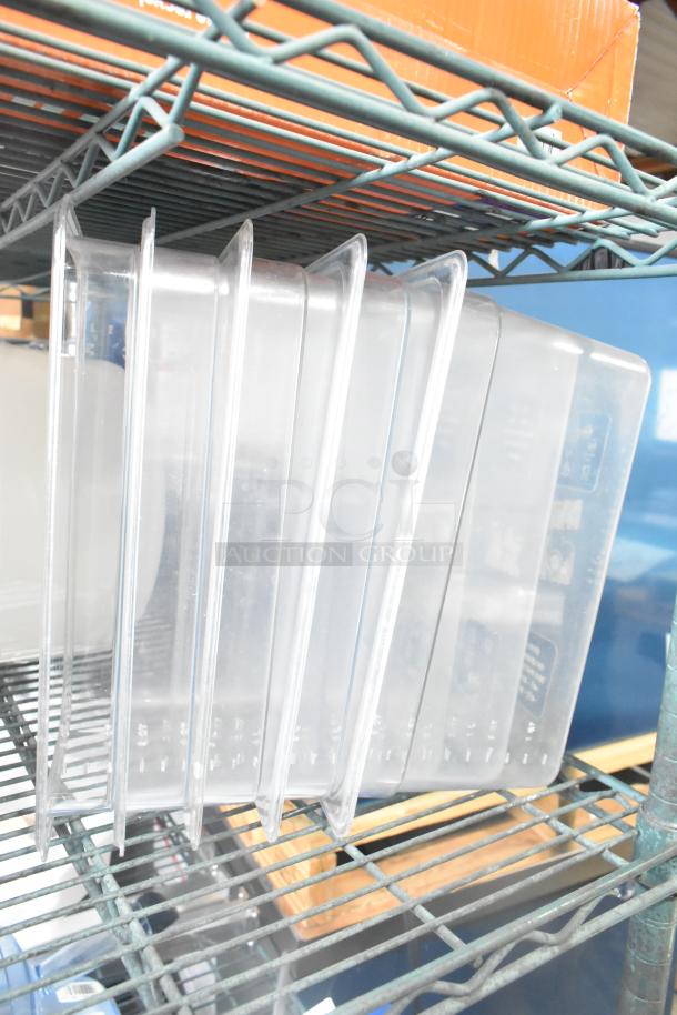 Three clear poly drop-in bin lids on a metal shelf, part of a mixed auction lot.