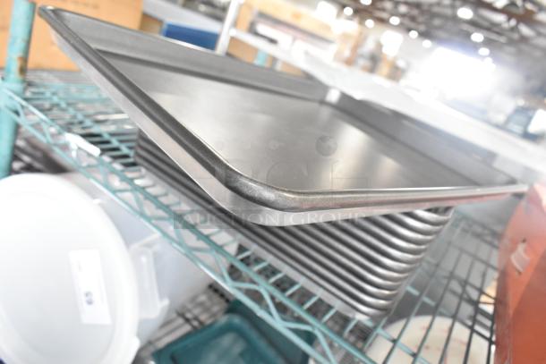 Alt Text: Stack of 12 metal half-size baking pans on wire shelf, in good condition, perfect for commercial kitchen use.