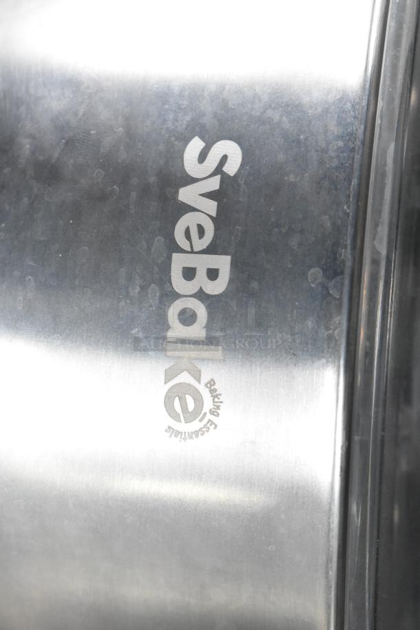 Metal bin with "SveBake Baking Essentials" logo, part of an auction lot with various storage items.