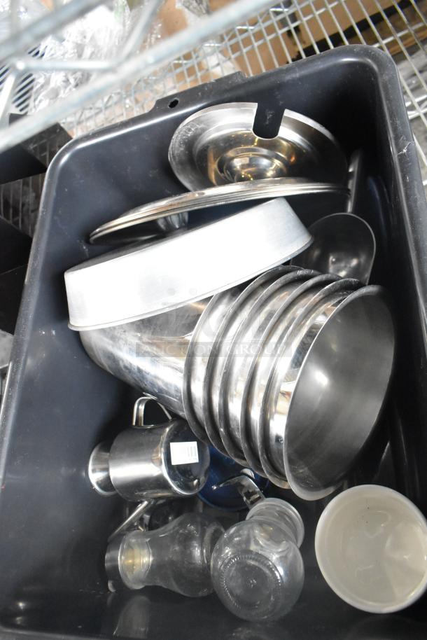 Bus bin containing various metal items, including bowls and pitchers, with visible barcode on one item.