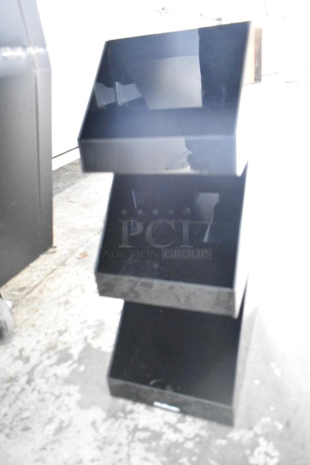 Black poly 3-tier rack in used condition. Features multiple storage shelves, suitable for organizing various items.