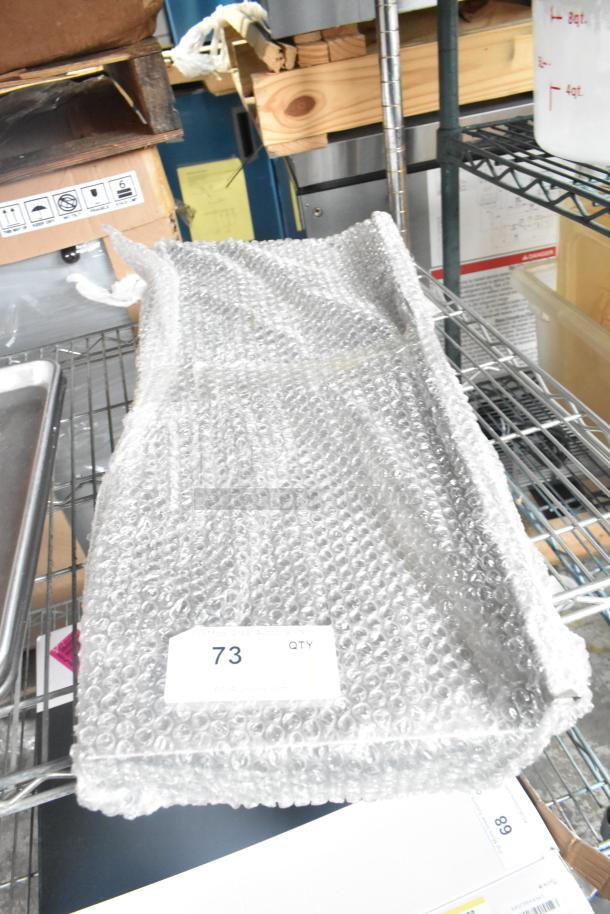 Bubble-wrapped metal shelf, label "73 QTY," on storage rack. Condition appears new.