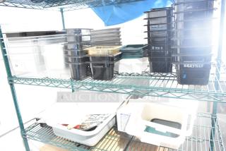 Two-tier shelf with poly drop-in bins, utensils, and ingredient bin. Various sizes, mostly black and clear. Good condition.