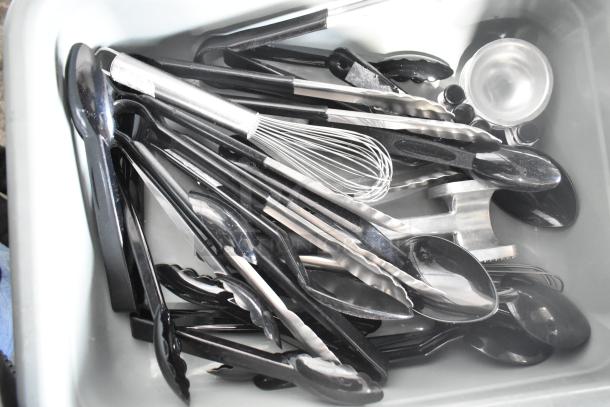 Two-tier lot of kitchen utensils in a poly drop-in bin, includes tongs, whisk, and scoops. Good condition.