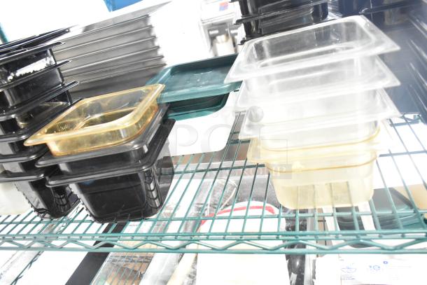 Two-tier lot with various poly drop-in bins, utensils, and ingredient bins on wire shelves. Items appear in used condition.