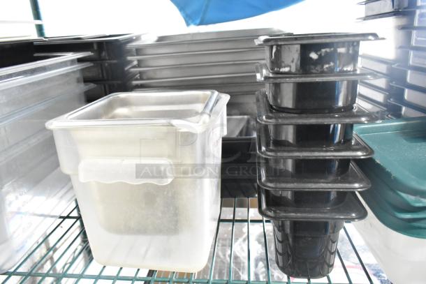 Two-tier lot of poly drop-in bins, various utensils, and ingredient bin. Includes transparent and black containers, good condition.