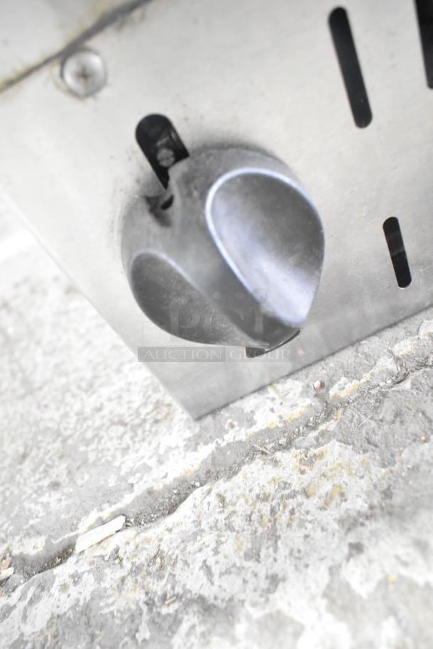 Alt text: Close-up of Vulcan Commercial Gas Cheese Melter control knob on a metal surface, showing slight wear.