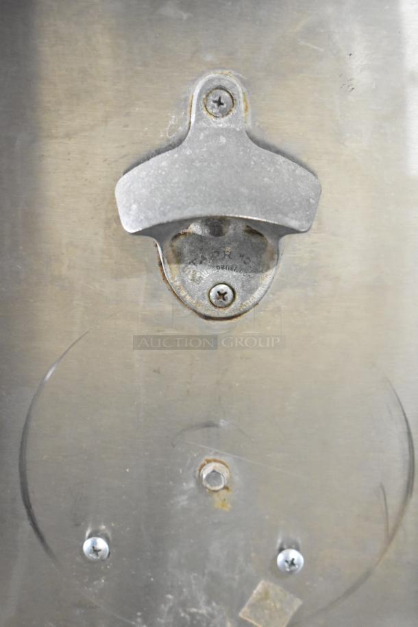 Krowne BC72-SS bottle cooler's metal surface detail with mounted bottle opener. Shows minor wear.