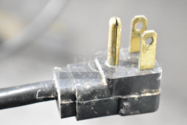 Close-up of a three-pronged plug connected to a Krowne BC72-SS Commercial Back Bar Bottle Cooler.
