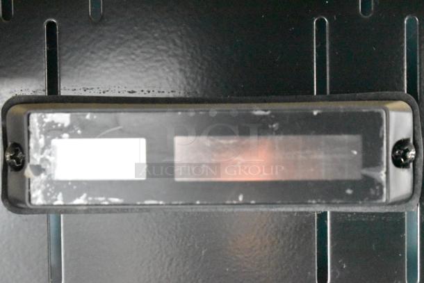 Close-up of label area on Structural Concepts Oasis CO47R Open Grab N Go Merchandiser, showing wear and unclear markings.