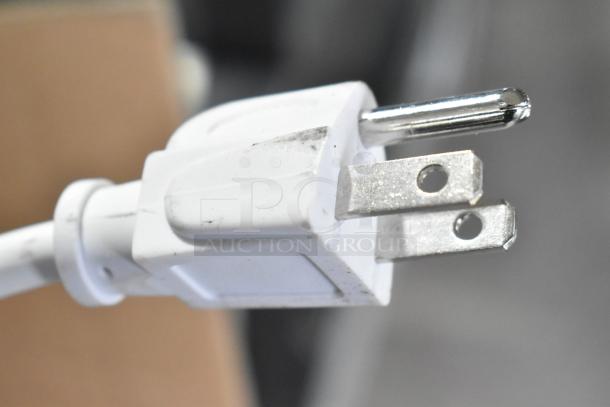 Alt text: Close-up of a white power plug connected to a Curton PRO=AP-2-36-1-SS Air Curtain. 120 Volts, 1 Phase.