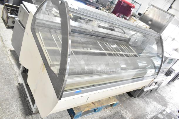 Strike C83F-G12-STL Gelato Case Merchandiser, floor model, 220V, 1 phase, large curved glass with visible wear, industrial setting.