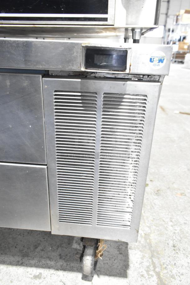 Delfield commercial 2-drawer chef base on casters, 115 volts, 1 phase. Stainless steel with ventilation grilles.