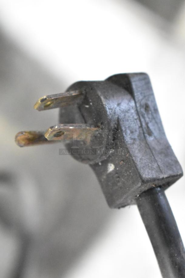 Close-up of a worn electrical plug for a Delfield Commercial Chef Base, 115 volts, showing its condition and metal prongs.
