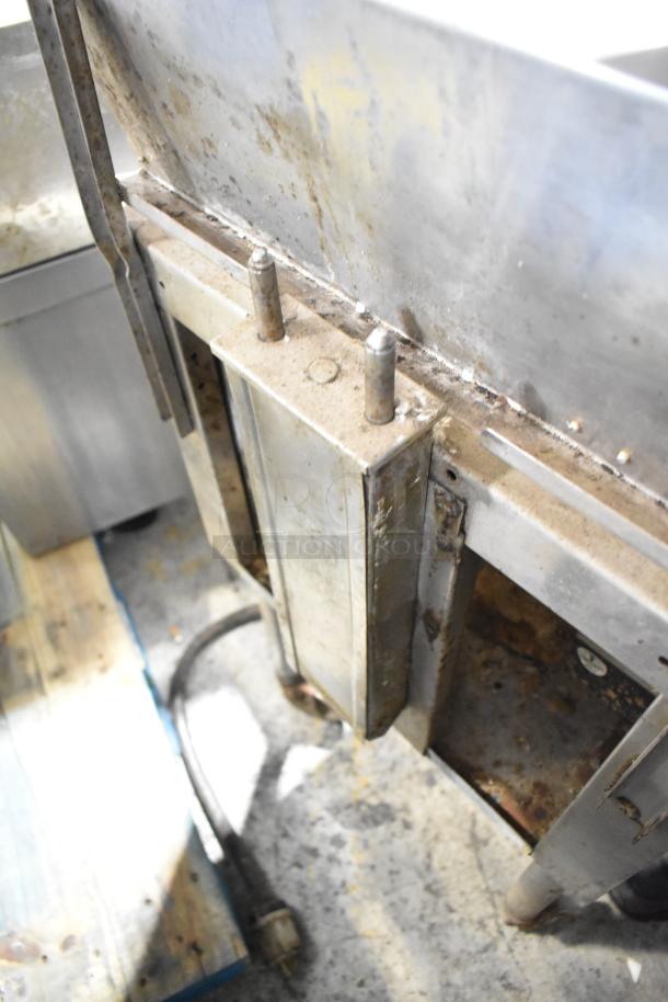 Commercial floor-style pressure fryer, stainless steel, visible wear and rust, showing pipes and base; used condition.