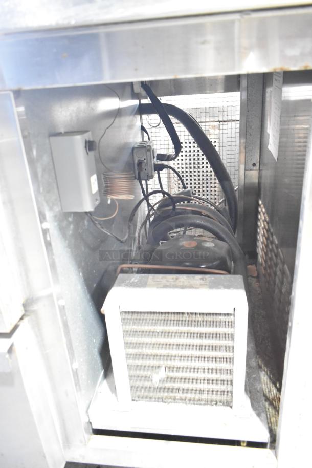 Continental CFB67-BS freezer internal view, showing compressor and wiring. Features 2 drawers, 1 door, on commercial casters.