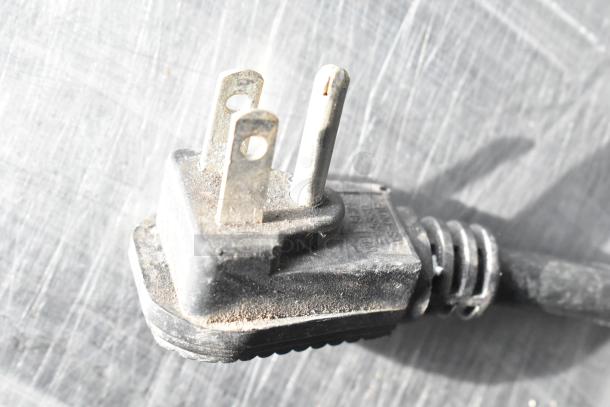 A close-up of a plug for a Continental CFB67-BS work top freezer, showing three prongs and signs of wear.
