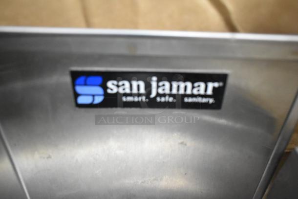 San Jamar lid dispenser with visible brand label, featuring a metallic surface; part of a lot including a faucet.