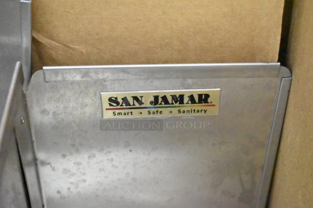 San Jamar lid dispenser with visible brand label, featuring "Smart, Safe, Sanitary," part of auction lot with various items.