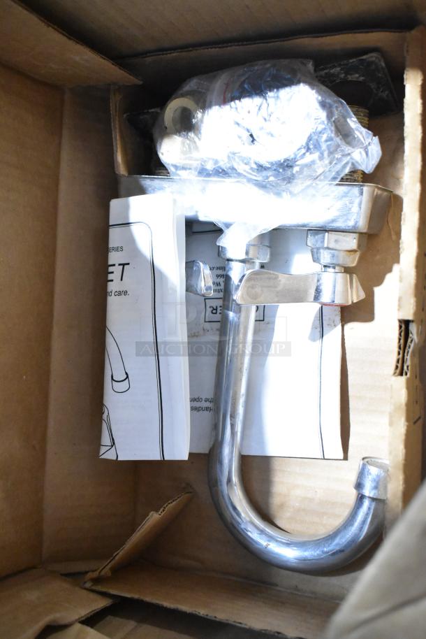 Box containing a faucet and San Jamar lid dispenser, both in new condition with wrapped components and instruction manuals.
