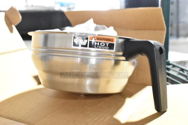 Stainless steel countertop juicer with black handle, "Hot Liquid" warning label, in open cardboard box.