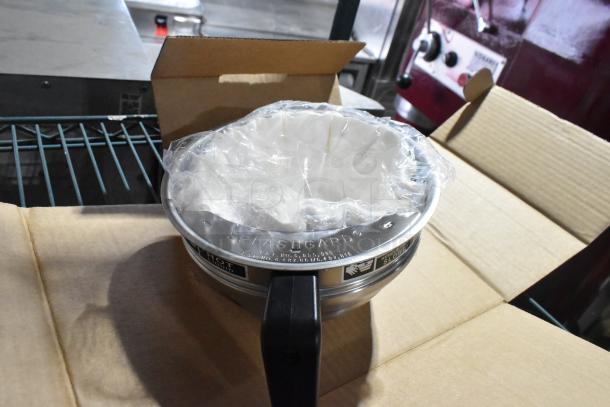 Countertop juicer with Splashgard feature, new in box. Includes protective plastic cover, black handle, and warning labels.