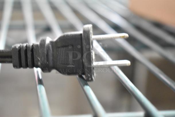 Electric plug for a countertop juicer, showing a close-up view. Unknown brand and model, appears in used condition.