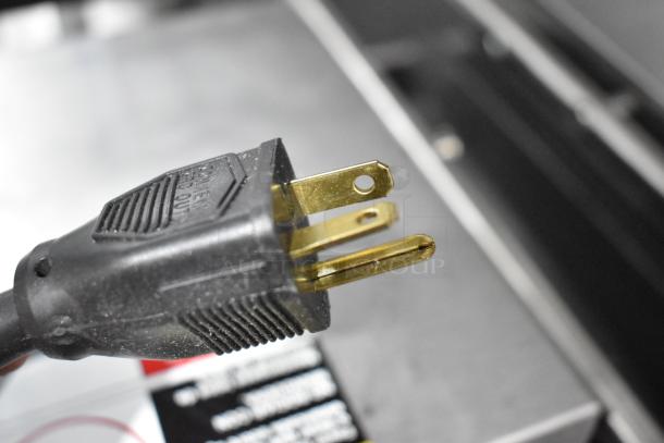 Close-up of a power cord plug for the Star GX20IG Panini Press, showing three-prong design.