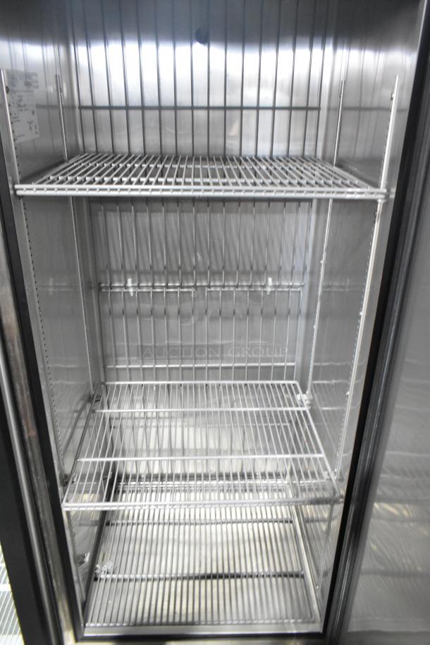 2016 True T-19F commercial single door reach-in freezer, shown open with three wire shelves, on casters. Model tag visible.