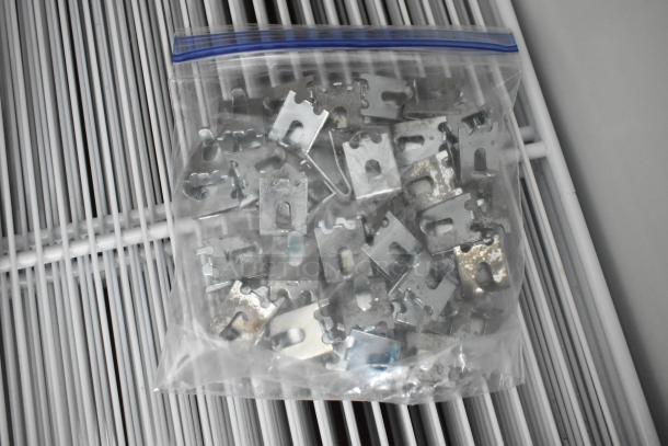 A bag of metal clips and pins on white wire shelving, part of a Habco SE18 cooler interior.