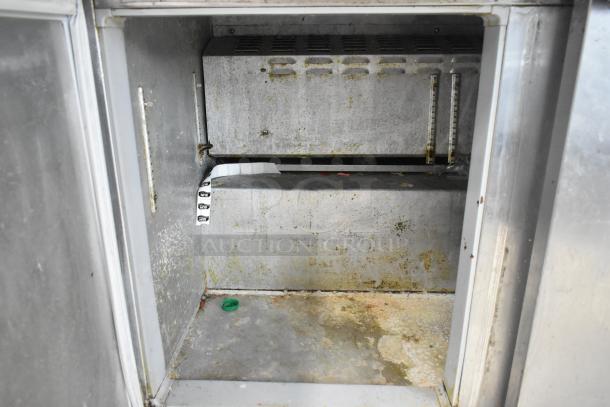 Continental SW48-18M prep table interior, showing worn, slightly stained stainless steel surfaces; NSF labels visible.