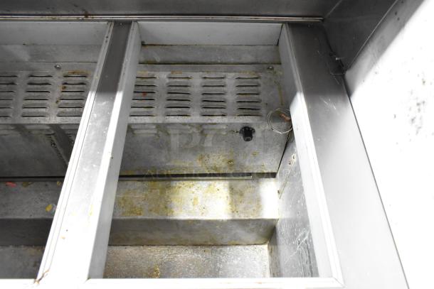 Continental SW48-18M prep table interior, showing metal compartments and ventilation slots. Some signs of wear and use.