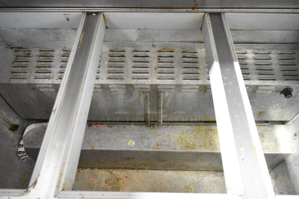 Continental SW48-18M prep table interior, showing metal shelving with visible wear, grime, and residue.